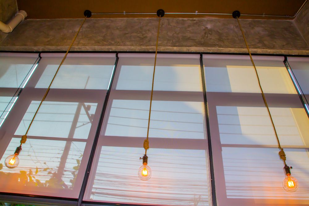 commercial drop down blinds behind retro hanging light bulbs